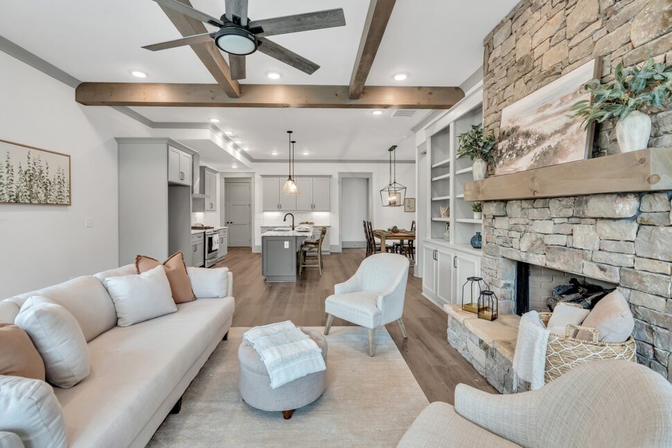 Spacious open layout showing living area, kitchen island, and dining space with pendant lighting.